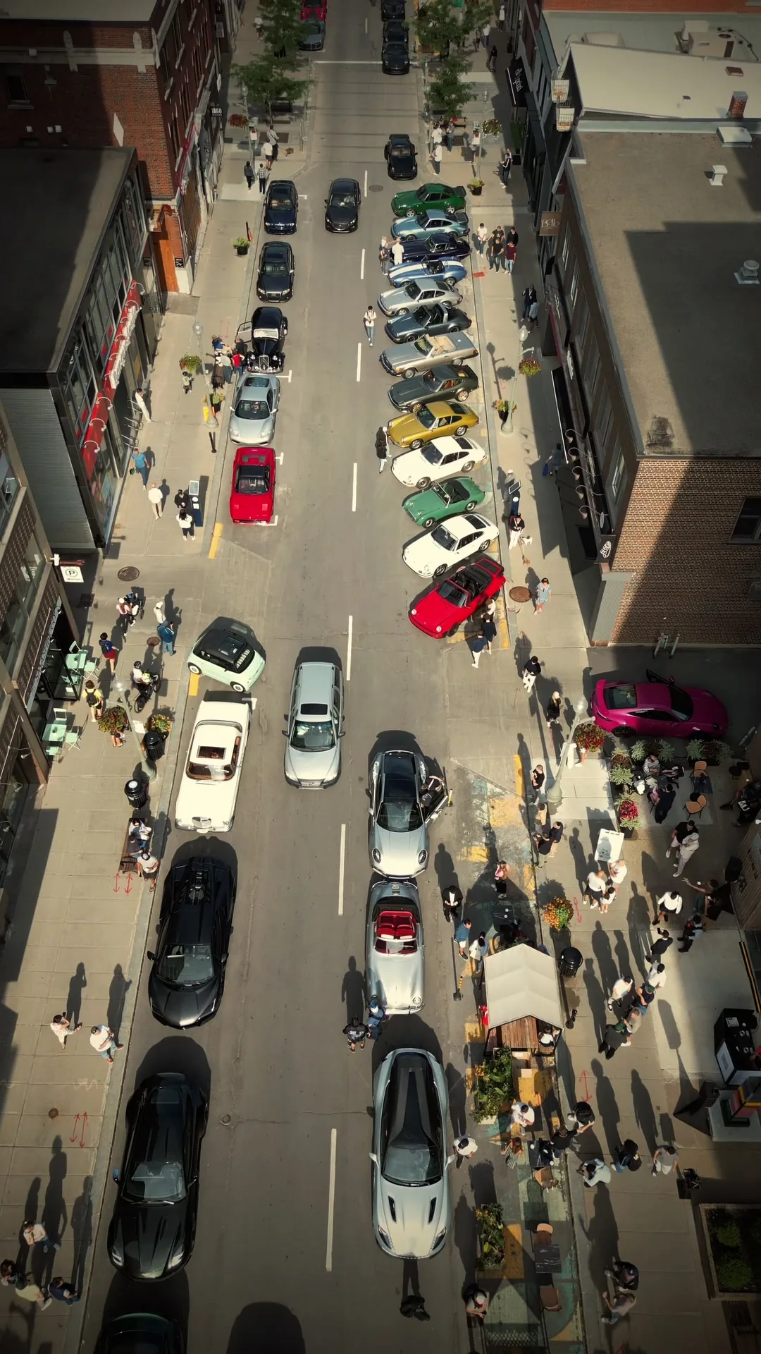 Greene Avenue seen from directly above: two rows of cars nosed in against the curb and the crowd spread along both sidewalks.